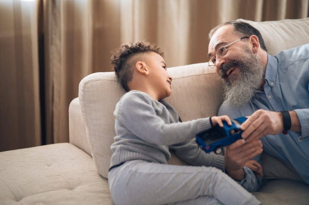 Grandfather and child playing with toy truck.