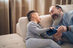 Grandfather and child playing with toy truck.